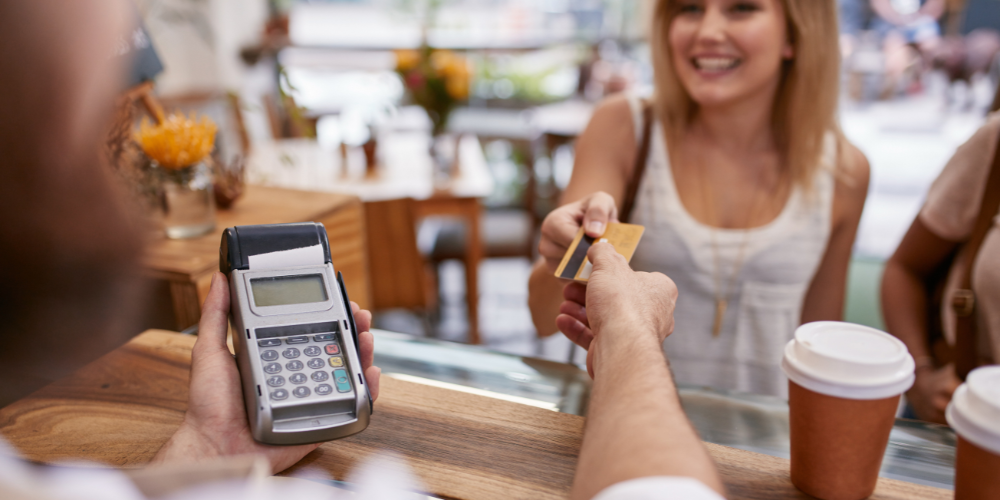 This image depicts a real-life interaction in a café, showing a person making a purchase. It represents a typical situation where a polyglot might practice language immersion through daily activities like ordering food or interacting with vendors.